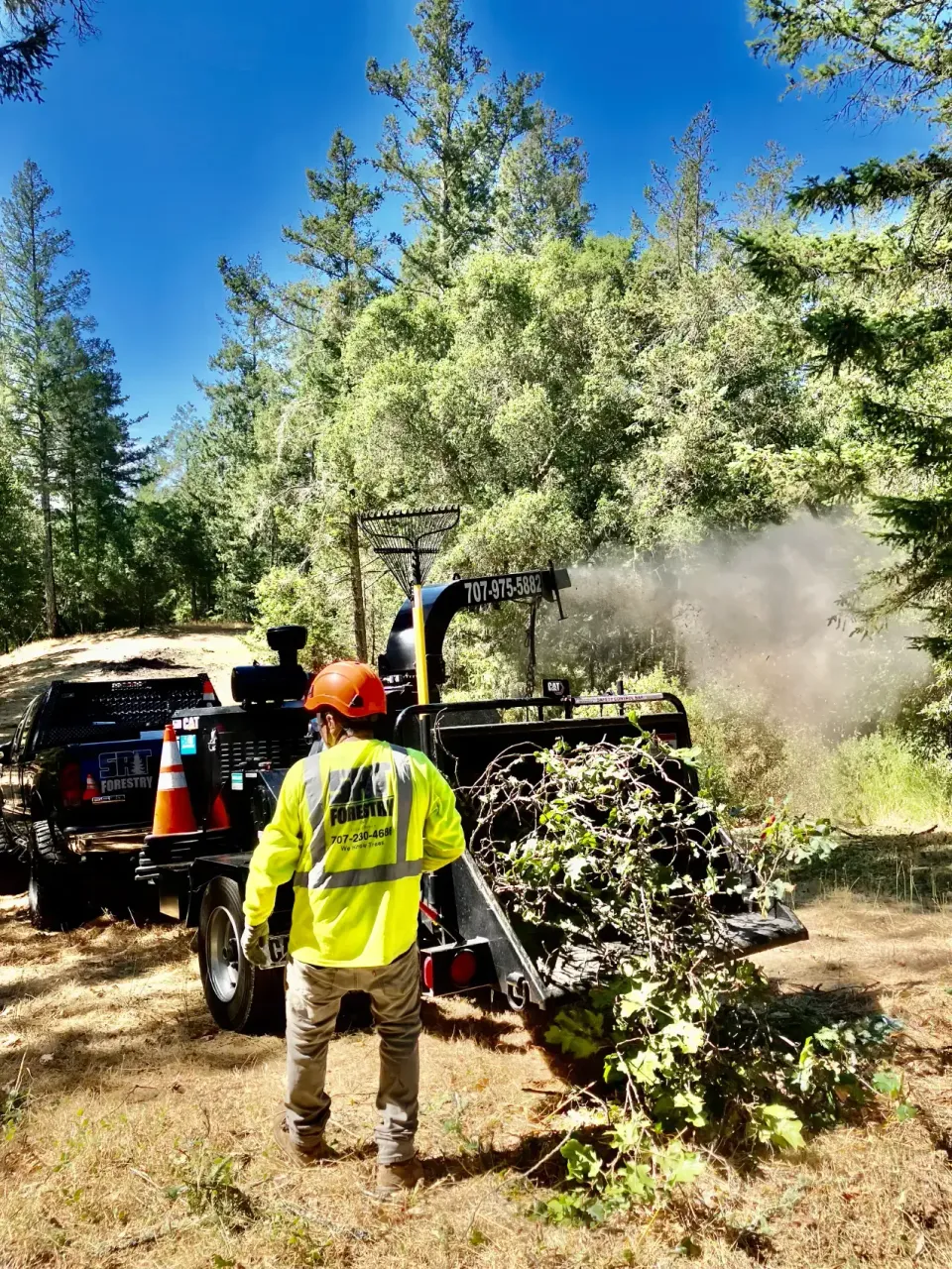 SRT Forestry crew processing branches with a chipper